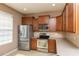 Modern kitchen featuring stainless steel appliances, wooden cabinets, and tile backsplash at 8409 Blue Rock Dr, New Port Richey, FL 34653