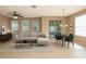 Open-concept living and dining area with modern decor, light-colored tile floors, and sliding glass doors at 8409 Blue Rock Dr, New Port Richey, FL 34653