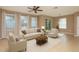 Bright living room featuring neutral-toned walls, plush seating, and natural light from multiple windows at 8409 Blue Rock Dr, New Port Richey, FL 34653