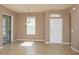 View of the living room with neutral walls and tile flooring, showing the front door and view to the backyard at 8409 Blue Rock Dr, New Port Richey, FL 34653
