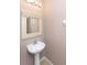 Image of the powder room featuring a pedestal sink, framed mirror, and neutral paint at 8409 Blue Rock Dr, New Port Richey, FL 34653