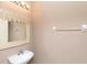 Close up of the pedestal sink and framed mirror in the powder room with a towel bar at 8409 Blue Rock Dr, New Port Richey, FL 34653