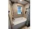 Updated bathroom with a tiled shower, storage niche, and a window at 8711 Jolly Roger Dr, Hudson, FL 34667