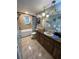 Standard bathroom featuring tan tile floors, a vanity with a vessel sink, and a shower-tub combination at 8711 Jolly Roger Dr, Hudson, FL 34667