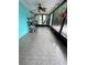Bright sunroom with tile flooring, ceiling fan, and screened windows at 8711 Jolly Roger Dr, Hudson, FL 34667