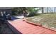 Brick paved walkway leads through outdoor space with greenery and a charming patio area at 8711 Jolly Roger Dr, Hudson, FL 34667