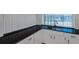 The kitchen sink has a dark countertop and white cabinets with dark hardware at 8807 Village Mill Row, Hudson, FL 34667