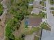 Aerial perspective showcasing a home with a screened-in pool, nestled in a well-maintained community at 9019 Flagstick Ln, Hudson, FL 34667