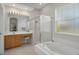 Well-lit bathroom featuring a soaking tub, glass shower, and vanity area at 9019 Flagstick Ln, Hudson, FL 34667