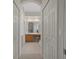 Hallway view of bathroom with well-lit vanity and ample closet space at 9019 Flagstick Ln, Hudson, FL 34667