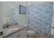 Bathroom featuring granite countertop, white cabinets and ocean-themed shower curtain at 9019 Flagstick Ln, Hudson, FL 34667