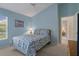 Light and bright bedroom with blue walls and neutral carpet at 9019 Flagstick Ln, Hudson, FL 34667