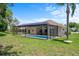 Landscaped backyard featuring a screened-in pool, creating a perfect setting for outdoor enjoyment at 9019 Flagstick Ln, Hudson, FL 34667