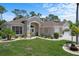 Charming single-story home with lush landscaping, manicured lawn, and an attached two-car garage at 9019 Flagstick Ln, Hudson, FL 34667