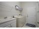 Bright laundry room with sink, washer, dryer, and storage shelf at 9019 Flagstick Ln, Hudson, FL 34667
