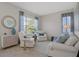 Inviting living room featuring white furniture, a decorative mirror, and ample natural light at 9019 Flagstick Ln, Hudson, FL 34667