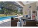 Screened patio with outdoor furniture and view of backyard pool at 9019 Flagstick Ln, Hudson, FL 34667