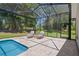 Comfortable seating area by the screened-in pool, offering a perfect spot to unwind and enjoy the view at 9019 Flagstick Ln, Hudson, FL 34667
