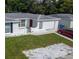 Aerial view features white single Gathering home with well-maintained lawn and red car parked at 9116 Gray Fox Ln, Port Richey, FL 34668