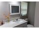 Well-lit bathroom featuring a quartz countertop, contemporary mirror and a view from the window at 9116 Gray Fox Ln, Port Richey, FL 34668