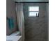 Modern bathroom featuring stylish gray tiling, a glass shower and contemporary fixtures at 9116 Gray Fox Ln, Port Richey, FL 34668