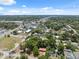 Aerial view of a quiet neighborhood street, surrounded by mature trees, on a sunny day under a vibrant blue sky at 9306 21St, Tampa, FL 33612