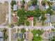 An aerial view shows a home with a vibrant red roof amidst the trees in a quiet neighborhood at 9306 21St, Tampa, FL 33612