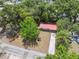 Aerial view of a well-maintained property with a red roof, a spacious yard, and mature trees at 9306 21St, Tampa, FL 33612