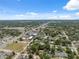 Wide aerial view showing a neighborhood with lush greenery and a variety of rooftops under a partly cloudy sky at 9306 21St, Tampa, FL 33612
