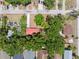 Aerial view of a home with a red roof surrounded by lush trees and a well-kept yard at 9306 21St, Tampa, FL 33612