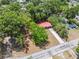 Aerial view of charming property featuring lush landscaping and a vibrant red roof, nestled in a verdant neighborhood at 9306 21St, Tampa, FL 33612