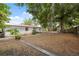 Wide-angle view of backyard with a red roof house, with ample space for outdoor activities and landscaping at 9306 21St, Tampa, FL 33612