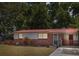 Charming single-story home featuring a red metal roof, brick accents, and a well-maintained front yard at 9306 21St, Tampa, FL 33612