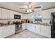 Bright kitchen with granite countertops, stainless steel appliances, white cabinets, and neutral tile floors at 9306 21St, Tampa, FL 33612
