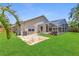The home's manicured backyard features a screened-in pool and a brick paver patio, perfect for outdoor living at 9729 Bay Colony Dr, Riverview, FL 33578