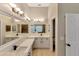 Bathroom with dual vanity, modern fixtures, and large mirror, well-lit at 9729 Bay Colony Dr, Riverview, FL 33578