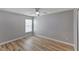 Neutral bedroom featuring wood-look floors and natural light from the window at 9729 Bay Colony Dr, Riverview, FL 33578