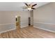 Bright bedroom with wood floors, ceiling fan, neutral paint, and multiple doorways at 9729 Bay Colony Dr, Riverview, FL 33578