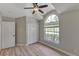 Bedroom features vaulted ceiling, closet, large window, and wood-look floors at 9729 Bay Colony Dr, Riverview, FL 33578