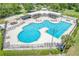 A high-angle shot of a community clubhouse and pools showing multiple swimming pools and outdoor seating at 9729 Bay Colony Dr, Riverview, FL 33578