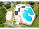 Aerial view of a community pool featuring a large swimming pool, beach volleyball court, sun deck, and lounging area at 9729 Bay Colony Dr, Riverview, FL 33578