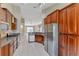 Well-equipped kitchen with stainless appliances, wooden cabinetry, and tile flooring at 9729 Bay Colony Dr, Riverview, FL 33578