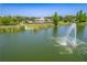 Beautiful lake view with a fountain, dock, and community building in the distance at 9729 Bay Colony Dr, Riverview, FL 33578