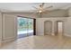 Bright living room with tile flooring, ceiling fan, and sliding glass doors to the pool at 9729 Bay Colony Dr, Riverview, FL 33578