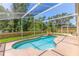 Inviting screened-in pool area with a charming rock waterfall feature perfect for relaxation and enjoying the outdoors at 9729 Bay Colony Dr, Riverview, FL 33578