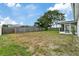 Spacious backyard featuring a wooden fence, mature tree, and screened-in patio for outdoor enjoyment at 9744 Rainelle Ln, Port Richey, FL 34668