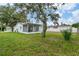 Backyard featuring a screened patio and plenty of greenery at 9744 Rainelle Ln, Port Richey, FL 34668