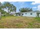 View of backyard featuring a screened patio and grassy area at 9744 Rainelle Ln, Port Richey, FL 34668
