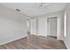 Bedroom features wood floors, ceiling fan, and view to the bathroom at 9744 Rainelle Ln, Port Richey, FL 34668