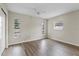 A bedroom features three windows, a ceiling fan, and wood-look flooring at 9744 Rainelle Ln, Port Richey, FL 34668